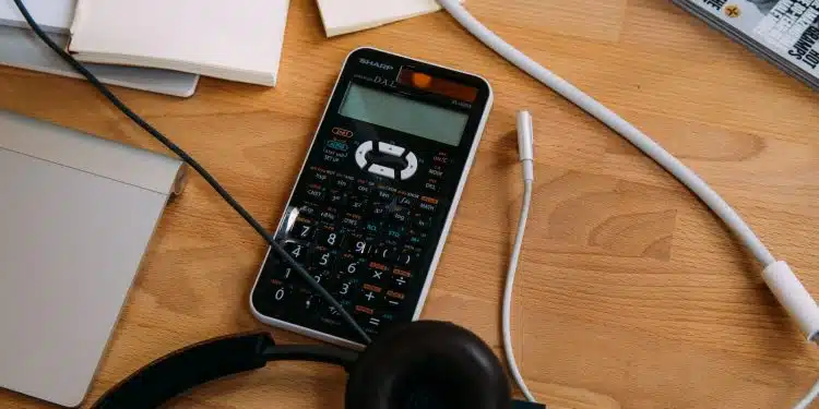 black scientific calculator beside black headphones